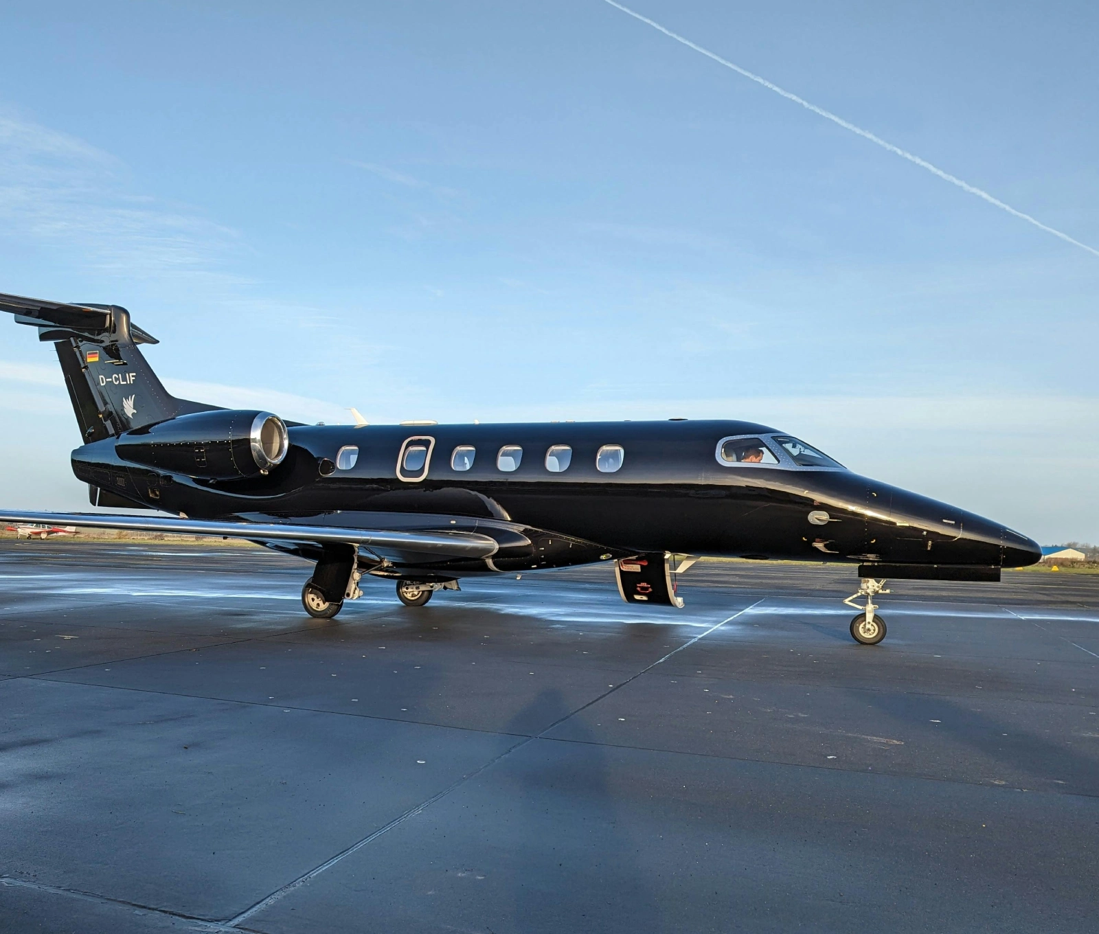 A black jet sitting on top of an airport runway.