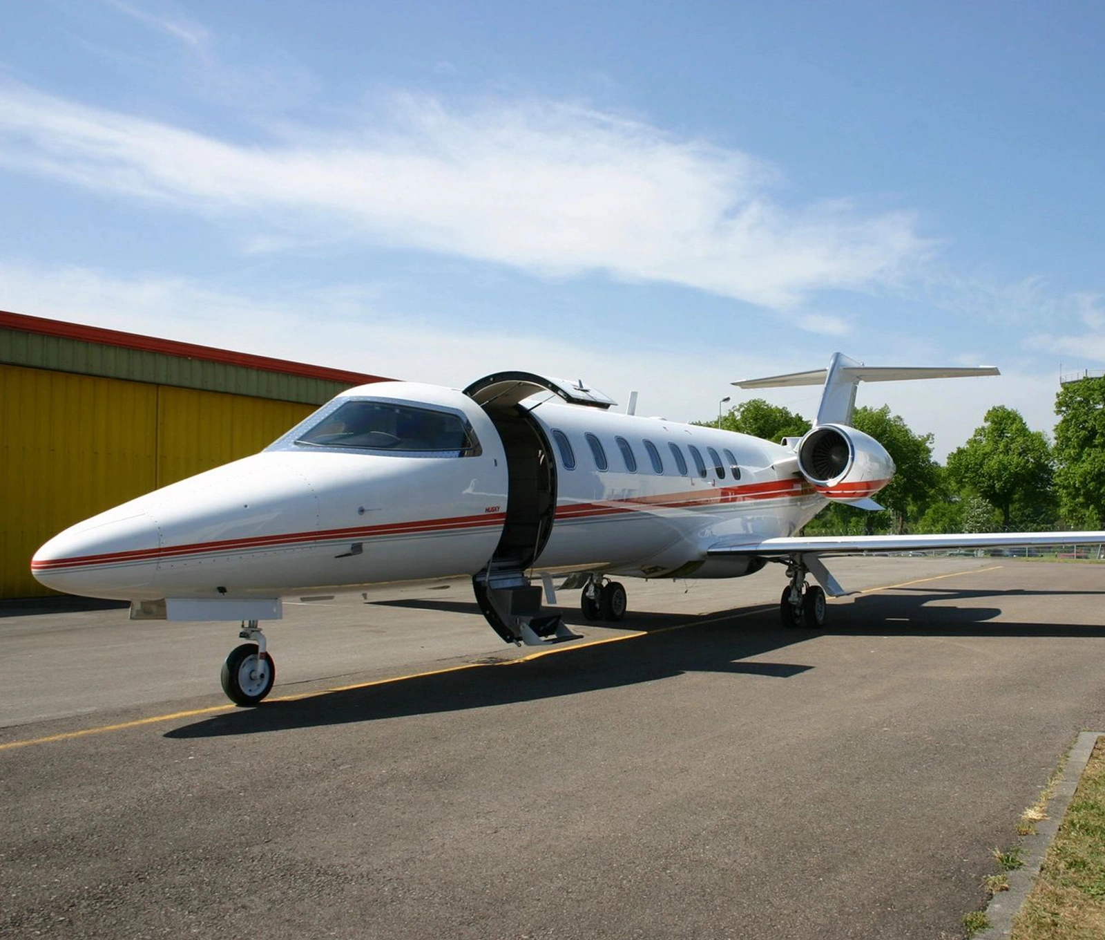 A small white jet sitting on top of an airport runway.